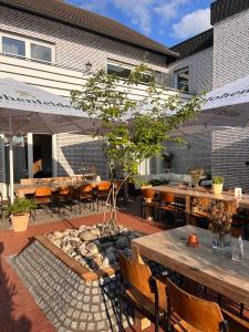eine Terrasse mit Tischen und Stühlen und einer Feuerstelle in der Unterkunft Hillerts Hotel in Rheda-Wiedenbrück