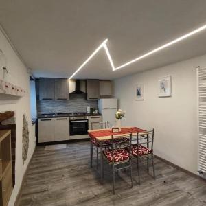 a kitchen with a table and chairs in a room at La ca veja in Locana