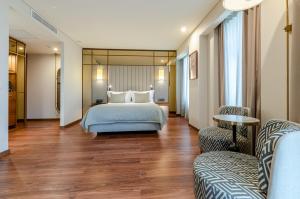 a hotel room with a bed and two chairs at TURIM Lisboa Hotel in Lisbon +66 photos