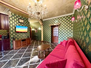 a living room with a pink couch and a chandelier at Jacuzzi With light Nauki Avene in Kharkiv