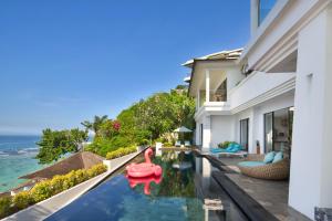 an infinity pool in a villa with a view of the ocean at Nusa Dua Cliff Ocean View with Private Beach in Nusa Dua
