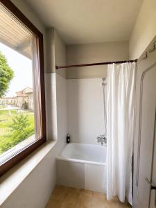 a bathroom with a bath tub and a window at Charm Studio - Large private terrace, Masserano in Masserano
