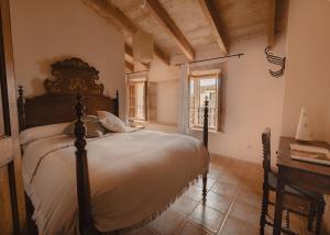 a bedroom with a bed and a desk and a window at Can Bagot, Turismo de Interior in Llubí