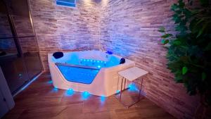 a hot tub with lights in a room with a brick wall at 16 Casita con Jacuzzi privado in Gran Alacant