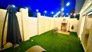 an outdoor patio with a table and an umbrella at 16 Casita con Jacuzzi privado in Gran Alacant +22 photos