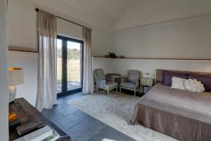 ein Schlafzimmer mit einem Bett, einem Tisch und Stühlen in der Unterkunft Paulīnes in Alsunga