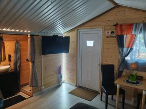 a room with a door and a table in a cabin at Fenyőházak in Buzsák
