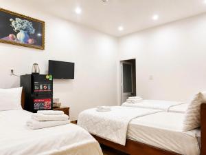 a room with three beds and a flat screen tv at KS Phương Danh in Quy Nhon +9 photos