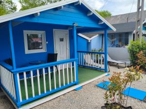 a blue play house with a porch at Fenyőházak in Buzsák