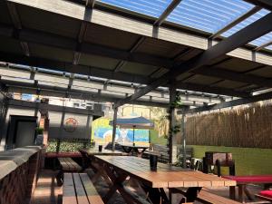 a patio with wooden tables and chairs and a blue umbrella at The Victoria Hotel in Collie