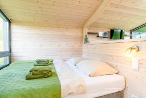 a bedroom with a bed in a wooden room at Naturverliebt am Diemelsee - Tiny House Wiesenblick in Heringhausen