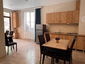 a kitchen with a table and chairs and a refrigerator at Memory- borjomi in Borjomi
