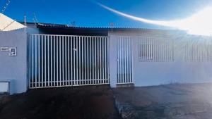 a white gate on the side of a building at Casa California - espaçosa in Formosa