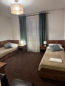 a hotel room with two beds and a window at Garden Zajazd in Rzeszów +21 photos