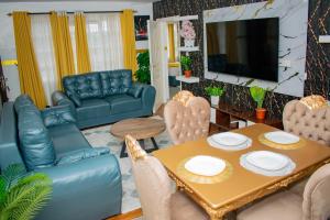 a living room with a table and chairs and a television at executive home in Eldoret