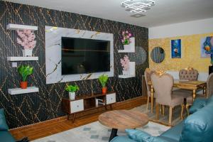 a living room with a tv and a table at executive home in Eldoret
