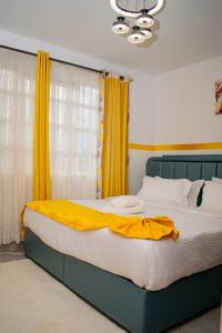 a bedroom with a large bed with yellow curtains at executive home in Eldoret