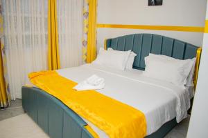a bedroom with a blue bed with a yellow blanket at executive home in Eldoret +9 photos