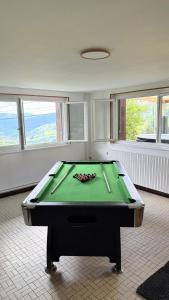 a room with a pool table with cue sticks at Le Repère De lAigle - Vue Panoramique in Cornimont