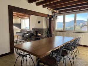 a dining room with a large wooden table and chairs at Le Repère De lAigle - Vue Panoramique in Cornimont