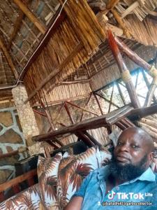 a man sitting on a couch in a hut at Bafadhil vacation home in Kilifi