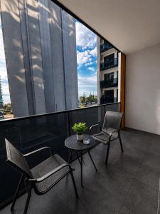 a balcony with two chairs and a table on a building at Hostly, New Boulevard Prime Stay in Batumi