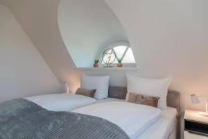 a bedroom with two beds and a window at Friesenfrühling in Borgsum