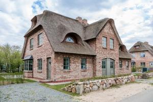 a large brick house with a shingled roof at Friesenfrühling in Borgsum