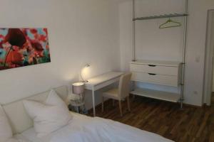 a bedroom with a bed and a desk with a lamp at Apartment Avenzio in Würzburg