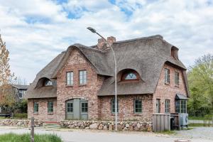 ein Haus mit einem Strohdach darauf in der Unterkunft Sommergeest in Borgsum