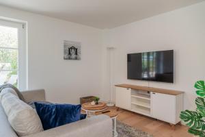a living room with a couch and a flat screen tv at Reetruhe in Borgsum