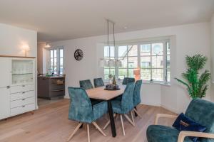 a kitchen and dining room with a table and chairs at Reetruhe in Borgsum