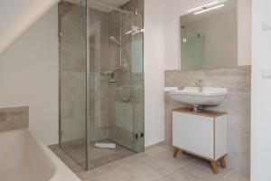 a bathroom with a glass shower and a sink at Reetruhe in Borgsum +18 photos