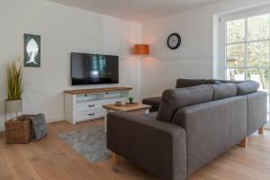 a living room with a couch and a flat screen tv at Wattenkieker in Borgsum