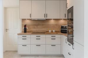 a kitchen with white cabinets and a counter top at Wattenkieker in Borgsum