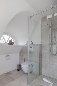 a bathroom with a glass shower and a toilet at Wattenkieker in Borgsum +19 photos