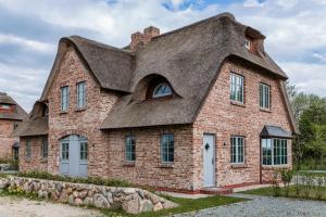an old brick house with a thatched roof at Wattenkieker in Borgsum