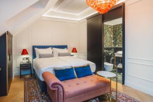 a bedroom with a large bed with a pink bench at Wonder - The Luxury Boutique Hotel in Budapest