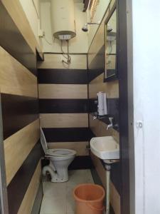 a small bathroom with a toilet and a sink at Sunrise Lodge in Varanasi