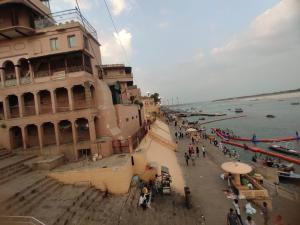 a group of people standing near a building next to the water at Sunrise Lodge in Varanasi