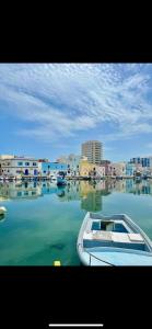 a boat in a body of water with buildings at Bizerte ,Tunisa with 2 rooms in Les Andalous