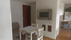 a living room with a table and a tv on the wall at J&K Štrba in Poprad
