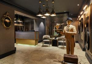 a statue of a man holding a wine glass at The Rex - formerly Hotel Gotham in Manchester