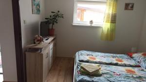 a bedroom with a bed and a desk and a window at J&K Štrba in Poprad
