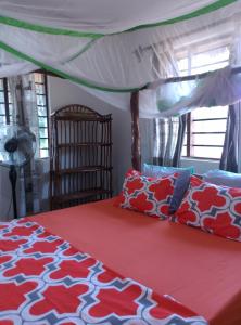 a bedroom with a bed with a canopy at Mango Lodge MSAMBWENI in Kisimachande