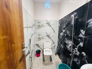 a bathroom with a black and white marble wall at HOTEL Blue Fin in Rānchī +13 photos