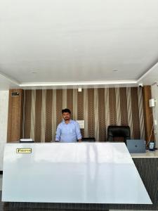 a man standing behind a table in an office at HOTEL Blue Fin in Rānchī