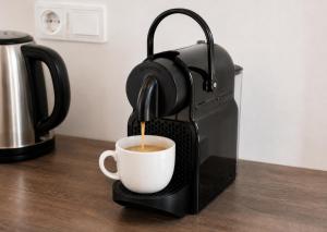 a coffee maker is making a cup of coffee at Studio spacieux et élégant au cœur de Bourbourg - gare à proximité in Bourbourg +15 photos