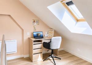a home office with a desk and a laptop at Studio spacieux et élégant au cœur de Bourbourg - gare à proximité in Bourbourg