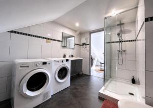 a bathroom with a washing machine and a shower at Studio spacieux et élégant au cœur de Bourbourg - gare à proximité in Bourbourg